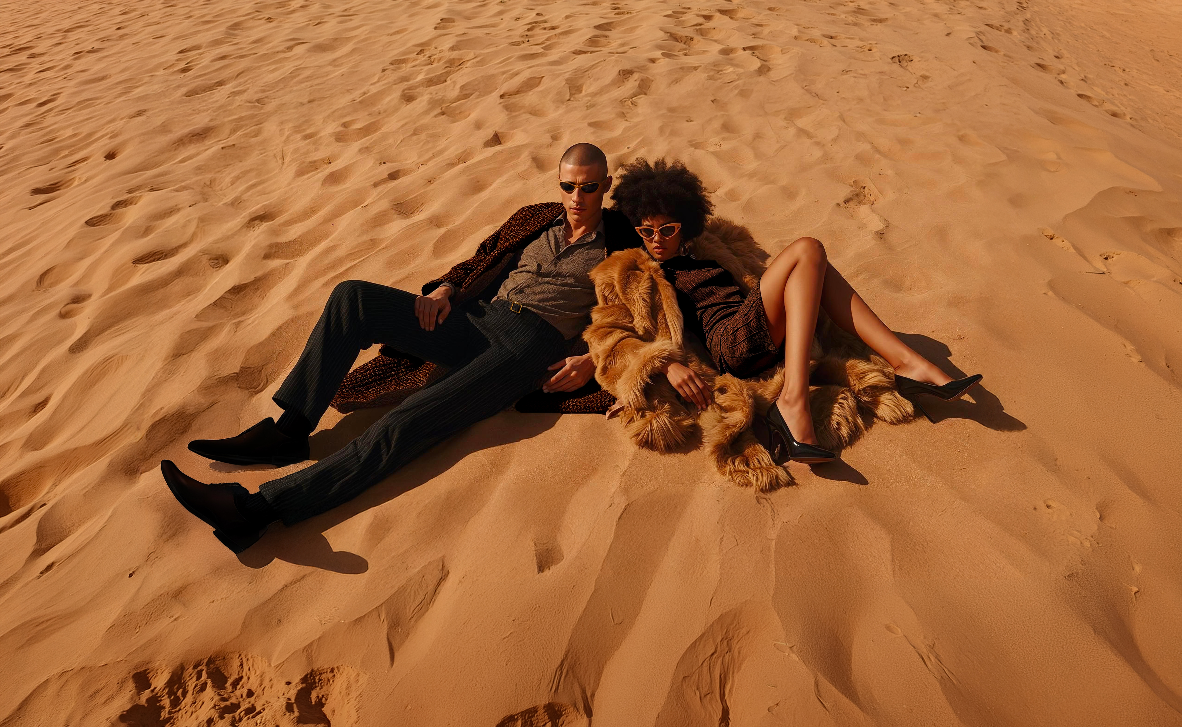 Models lying on the desert dunes posing for the Stonebloc fashion campaign